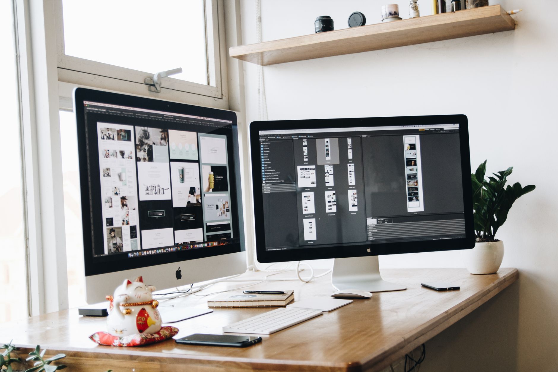 To skærme med designprogram på kontorbord